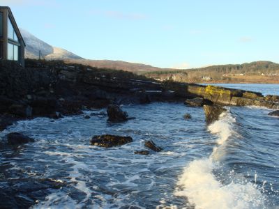 view from shore adjacent to seaside, with part of kitchen/breakfast room window to the far left